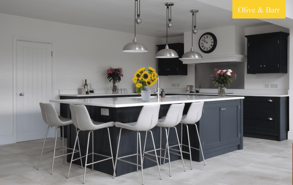 Modern navy blue shaker kitchen with feature lights, lots of flowers and large kitchen island