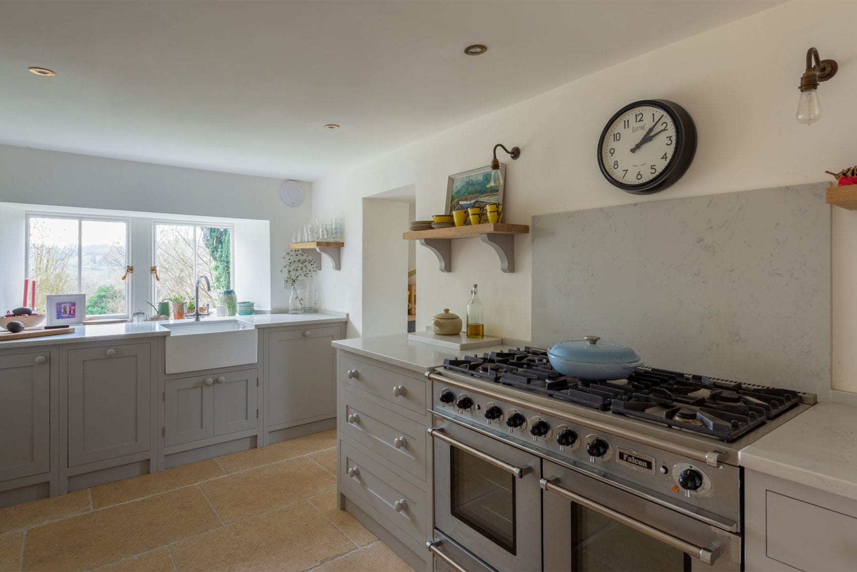 A Light grey shaker kitchen design with white walls and large oven
